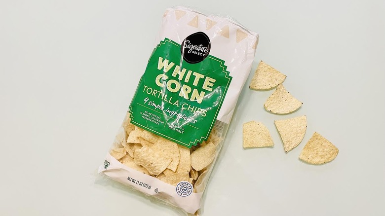 A bag of Signature Select White Corn Tortilla Chips is shown.