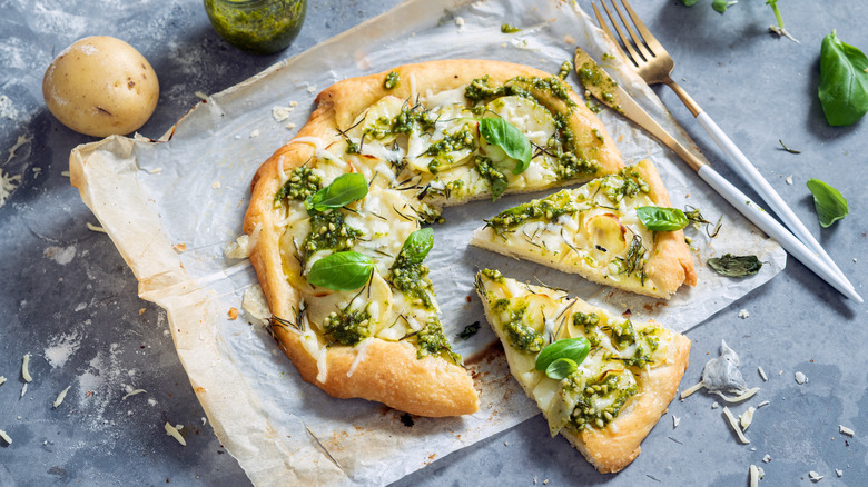 Pesto pizza on baking parchment