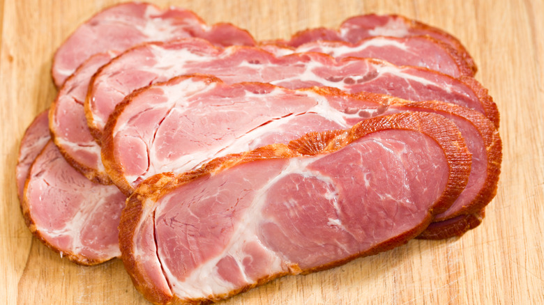 several slices of cottage bacon on a light wood table