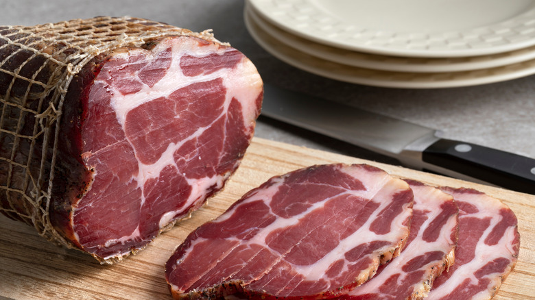 collar bacon with sliced pieces on a cutting board