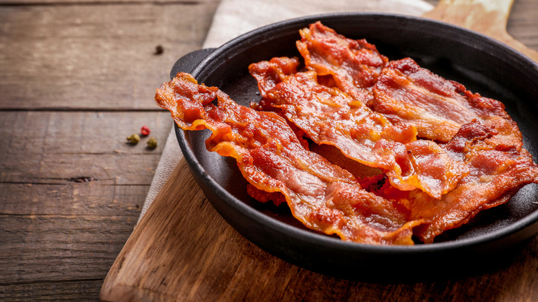a pan of crisp, fried bacon against a rustic backdrop