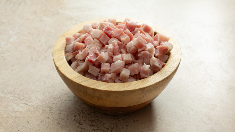 a wooden bowl of diced pancetta