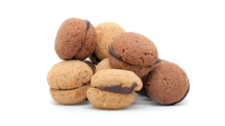 Baci di dama cookies in a pile on isolated white background