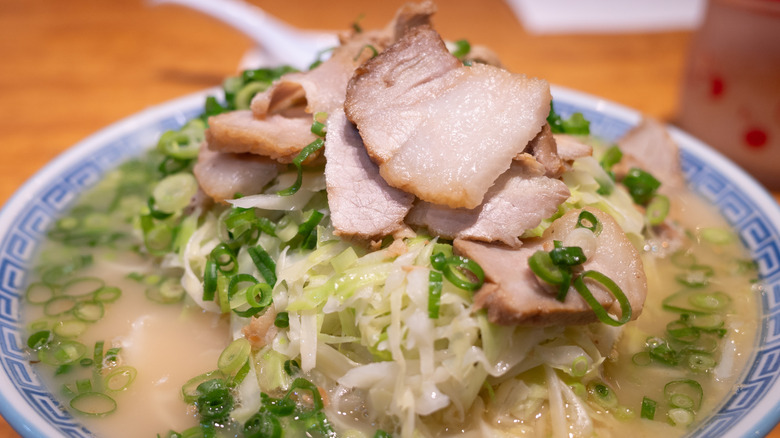 Kagoshima ramen topped with chashu, scallions, and green cabbage
