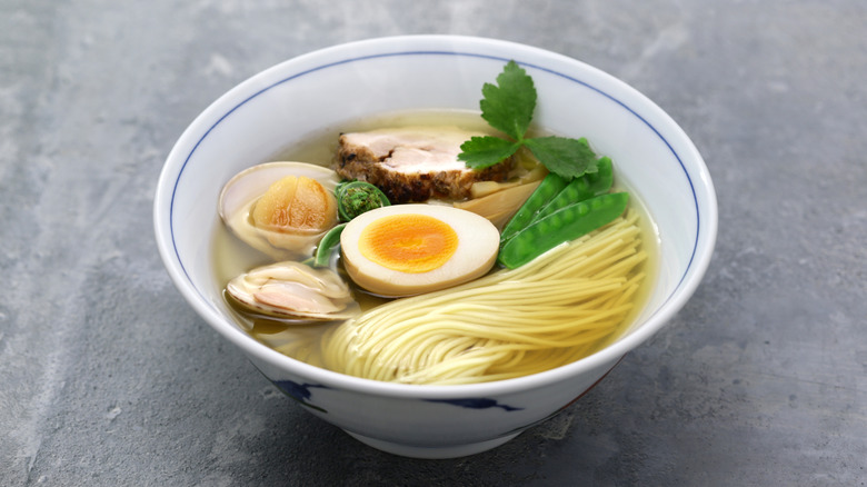 a White bowl of shio ramen topped with various ingredients