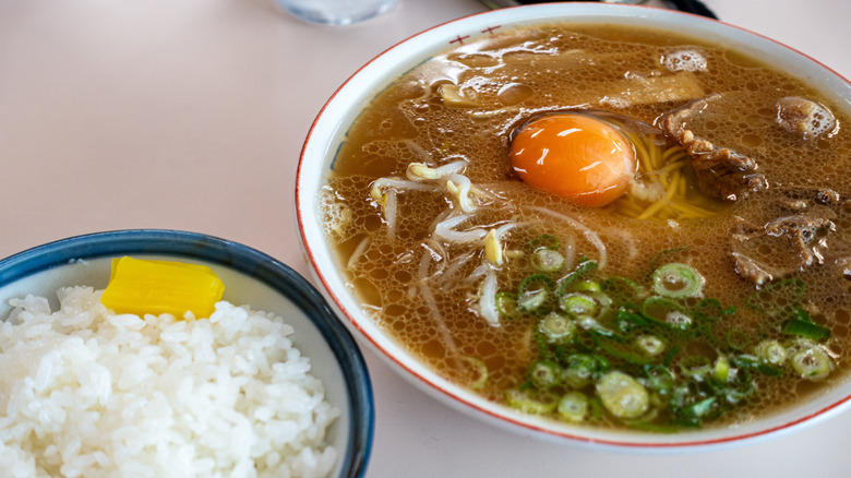 A bowl of Tokushima ramen with side of white rice on a table