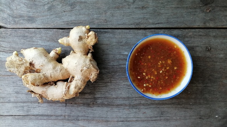 Ginger sauce in blue and white bowl next to ginger root