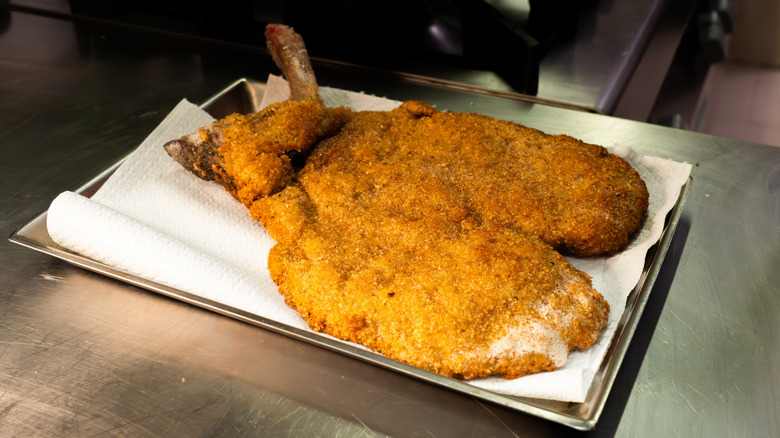 Freshly fried Milanese costoletta resting on paper towels