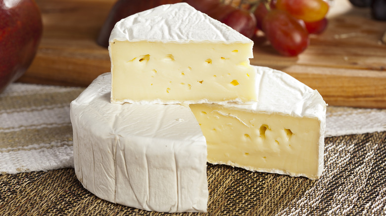 A block of brie cheese with a wedge cut out
