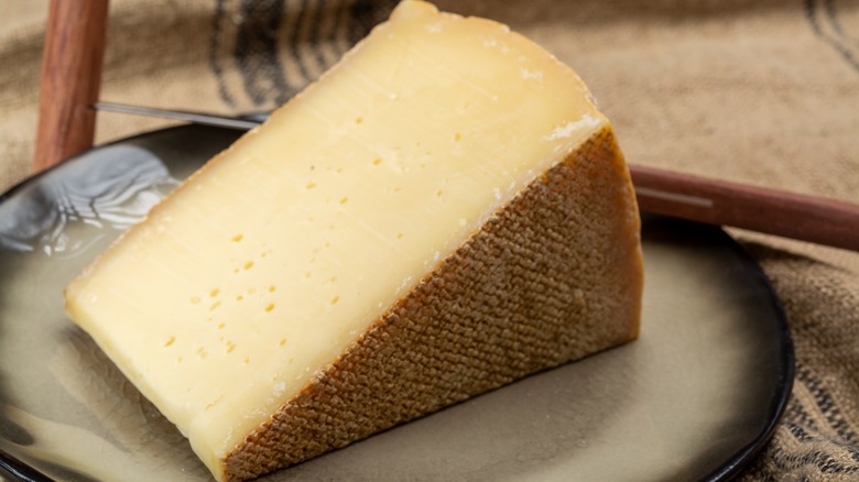A wedge of gruyère on a plate