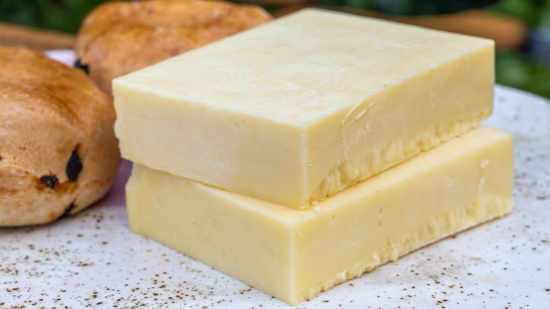 Two blocks of white cheddar on a plate