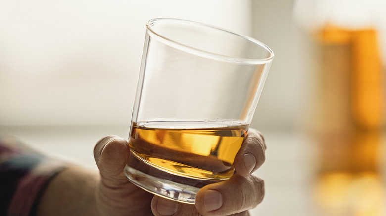 Person holding glass of bourbon