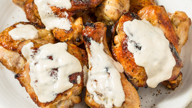 Pieces of grilled chicken with an Alfredo sauce drizzle