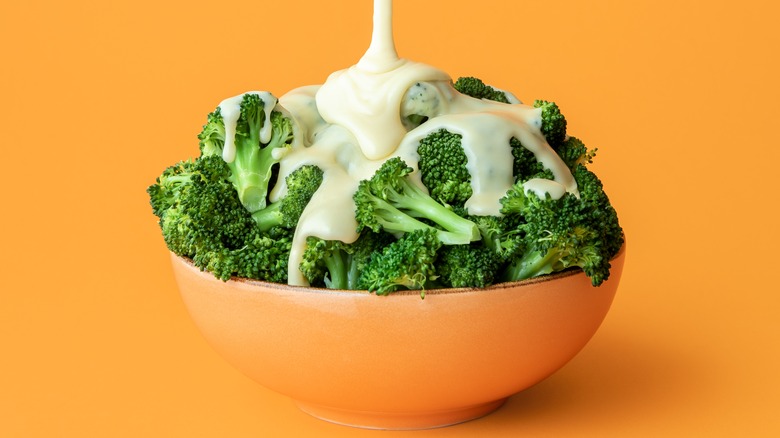 Bowl of broccoli with drizzle of Alfredo sauce
