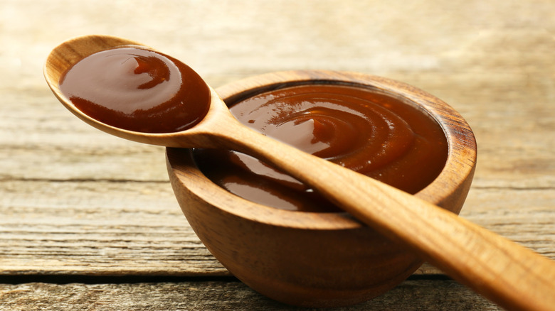 barbecue sauce in wooden bowl with spoon