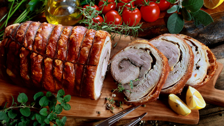 rolled porchetta surrounded by fresh ingredients