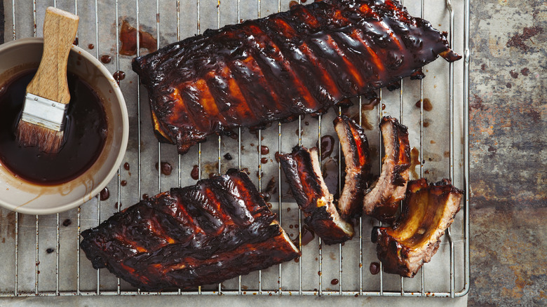 basting brush with sauce and rack of ribs