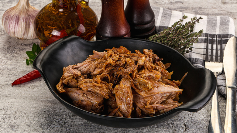 pulled pork in black bowl with ingredients