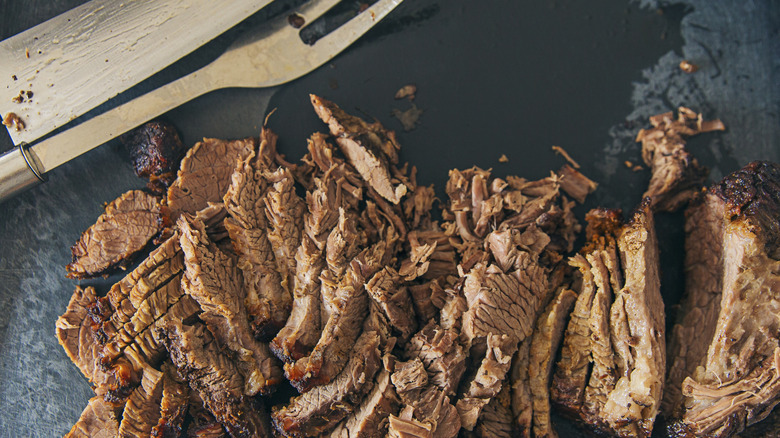 sliced up brisket near fork and knife