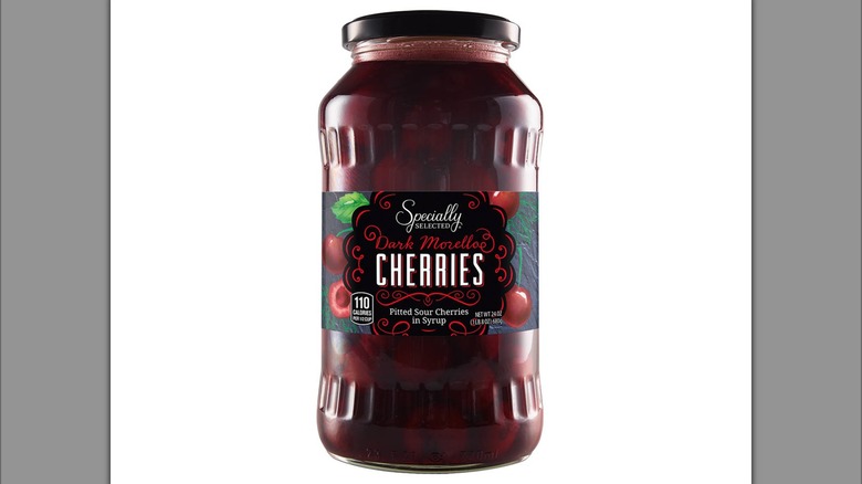 A glass jar filled with sour cherries in syrup