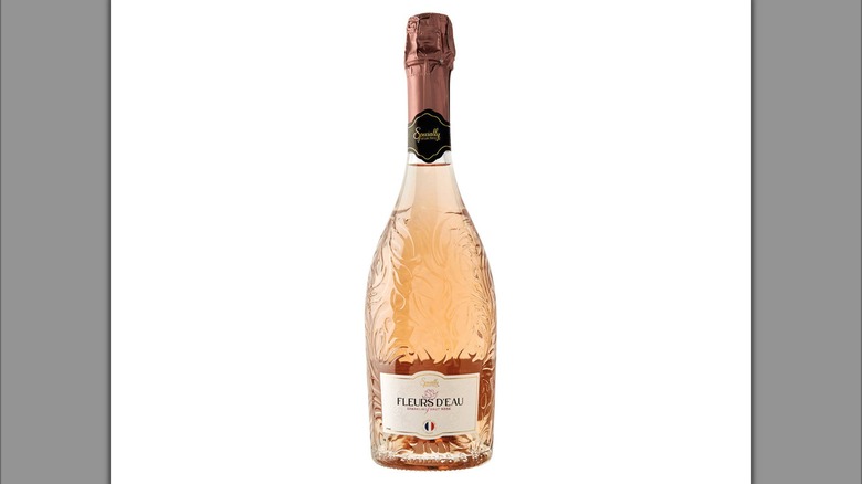 A glass wine bottle filled with rose sparkling wine.