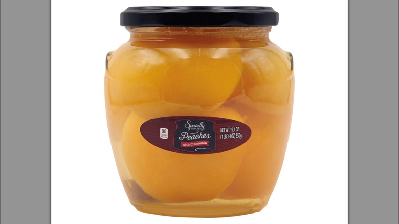 A glass jar filled with sliced peaches