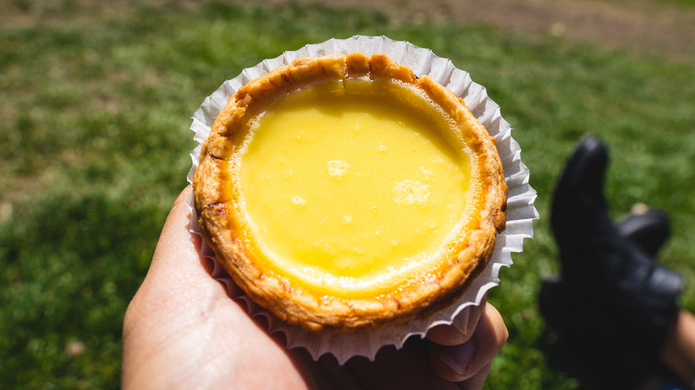 person holding custard egg tart