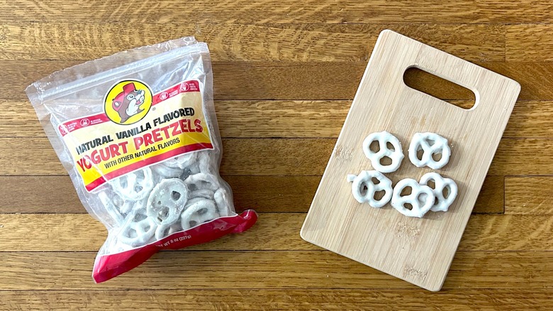 Package of and handful of Buc-ee's Natural Vanilla Flavored Yogurt Pretzels on a wooden cutting board