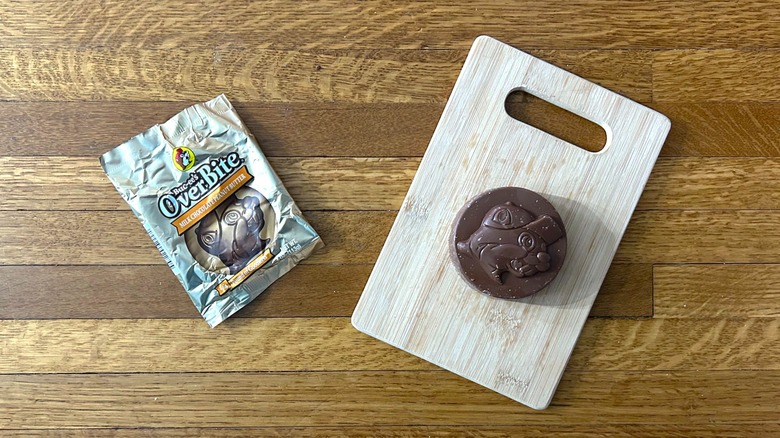 Package of and whole Buc-ee's OverBite Milk Chocolate Peanut Butter on a wooden cutting board