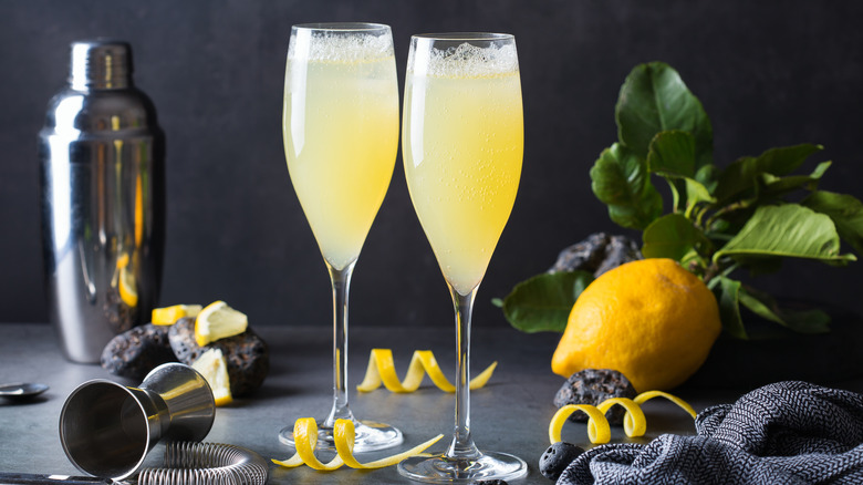 Two champagne flutes filled with French 75 cocktail