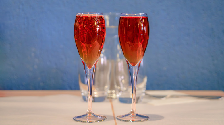 Two Champagne flutes filled with Kir Royale cocktail