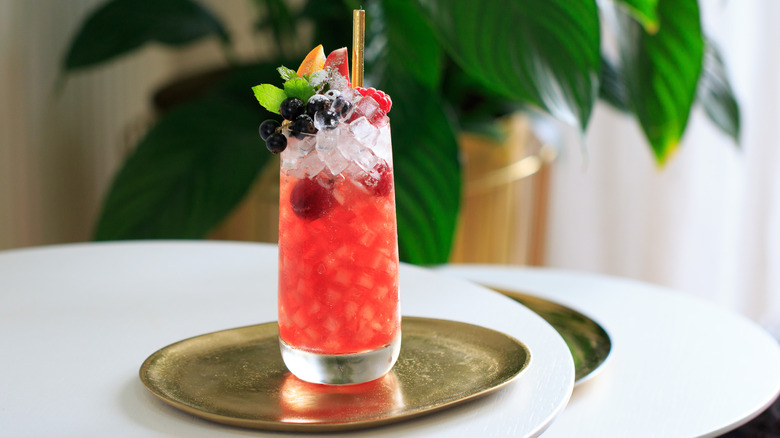 Highball glass filled with crushed ice and pink Sherry Cobbler cocktail