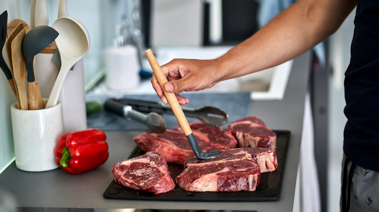 Person brushing meat with marinade