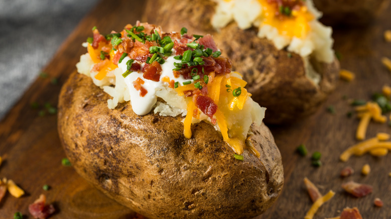 Baked potato with cheese, sour cream, and bacon on top