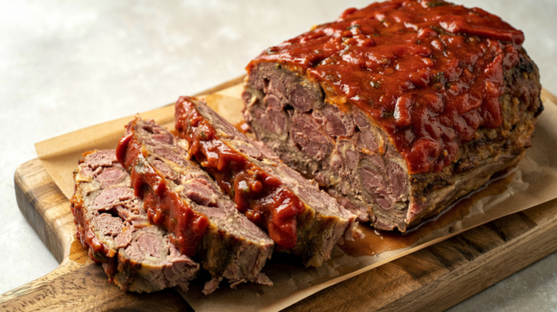 Meatloaf with ketchup topping on wooden cutting board