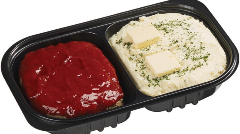 Meatloaf with sauce and mashed potatoes with butter pats