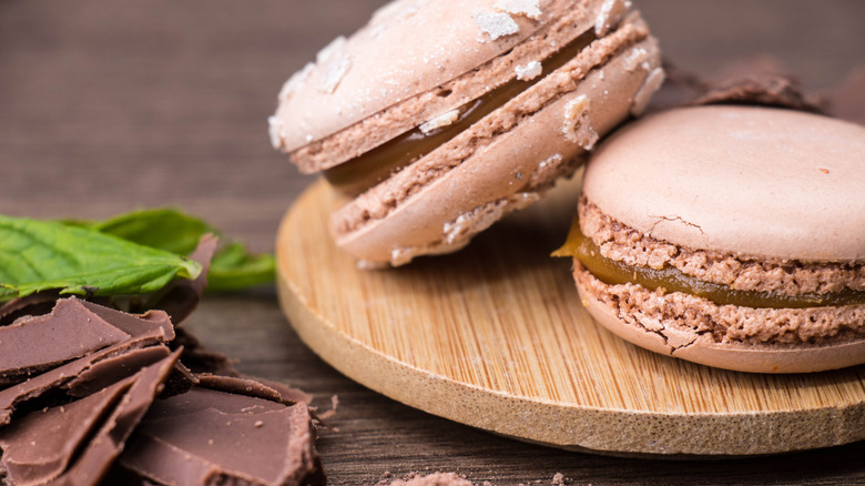 chocolate macarons with nutella on wood plaque