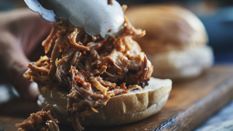 Putting pulled pork on a sandwich