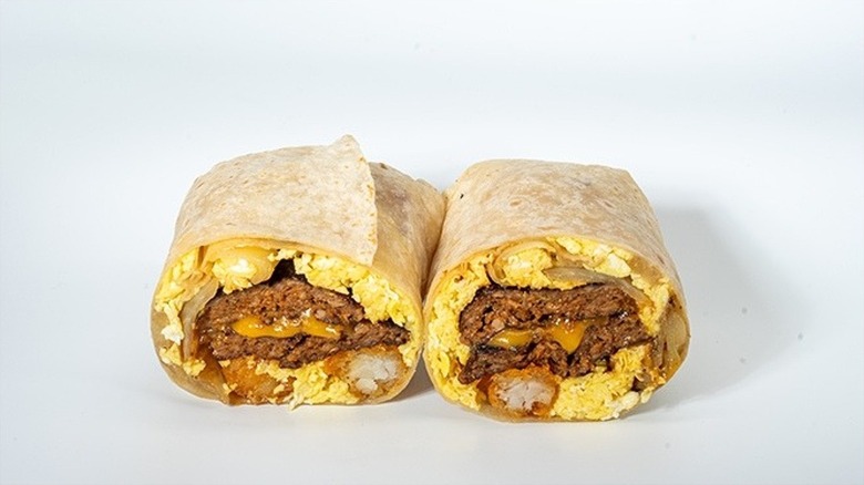 A breakfast burrito cut in half with eggs and Korean patty meat inside.