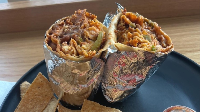 Tacos Villa Corona burrito on black plate with chips