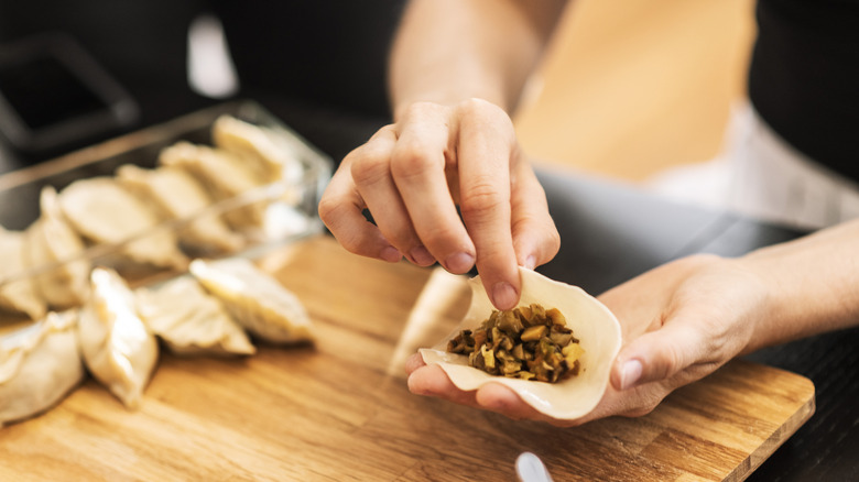 A person stuffing dumplings by hand