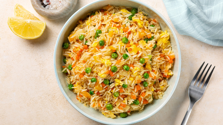 A bxowl of fried rice with eggs and peas
