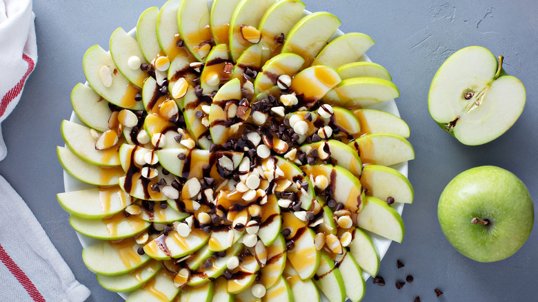 Apple nachos on a plate with caramel and chocolate