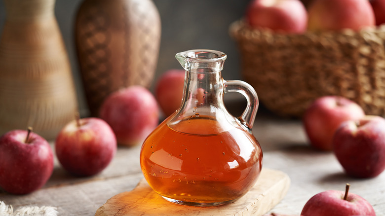 Apple cider in a container with whole fruit