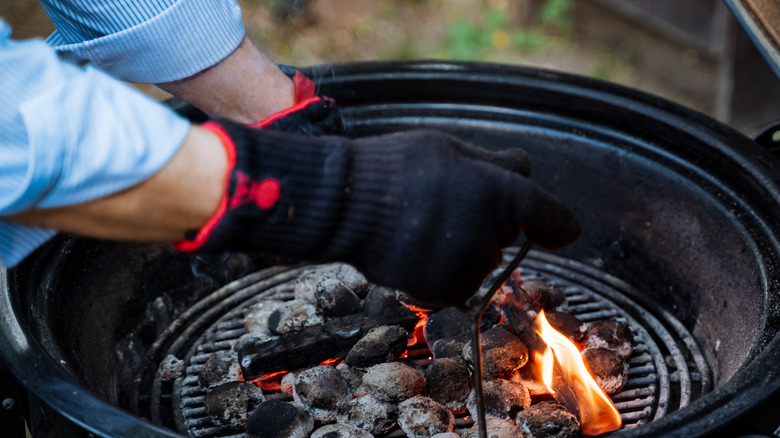 man with gloves staking coals