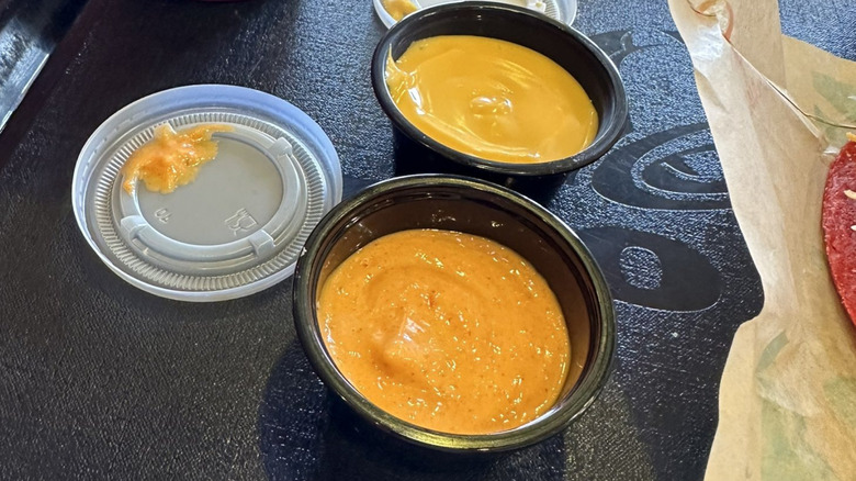 Two tubs of Taco Bell lava sauce with the lids off