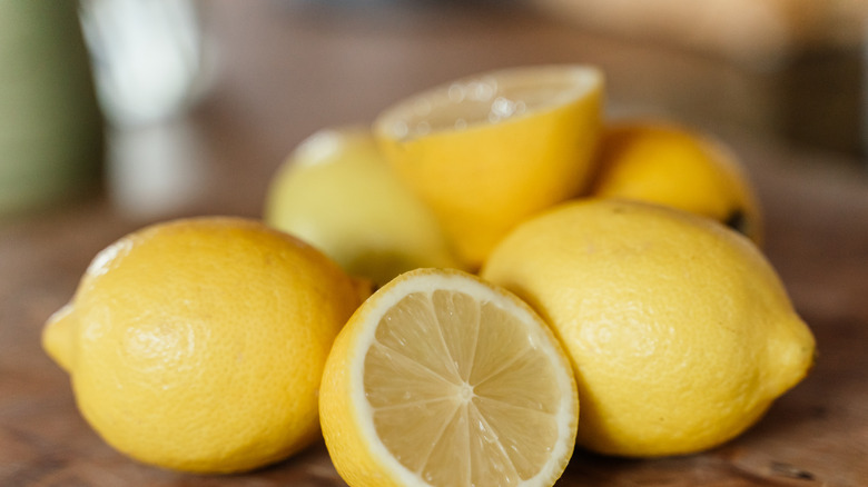 fresh lemons cut in half on cutting board