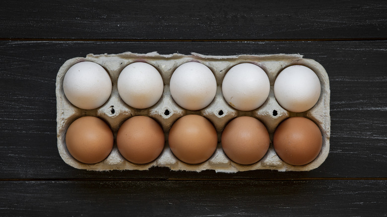 brown and white eggs in carton