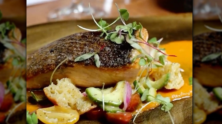 Sauteed fish over bed of vegetables sprinkled with fresh herbs