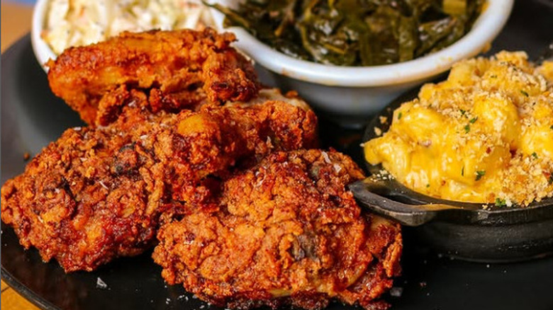 A platter with fried chicken, mac and cheese, collard greens, and coleslaw at Pinewood Social